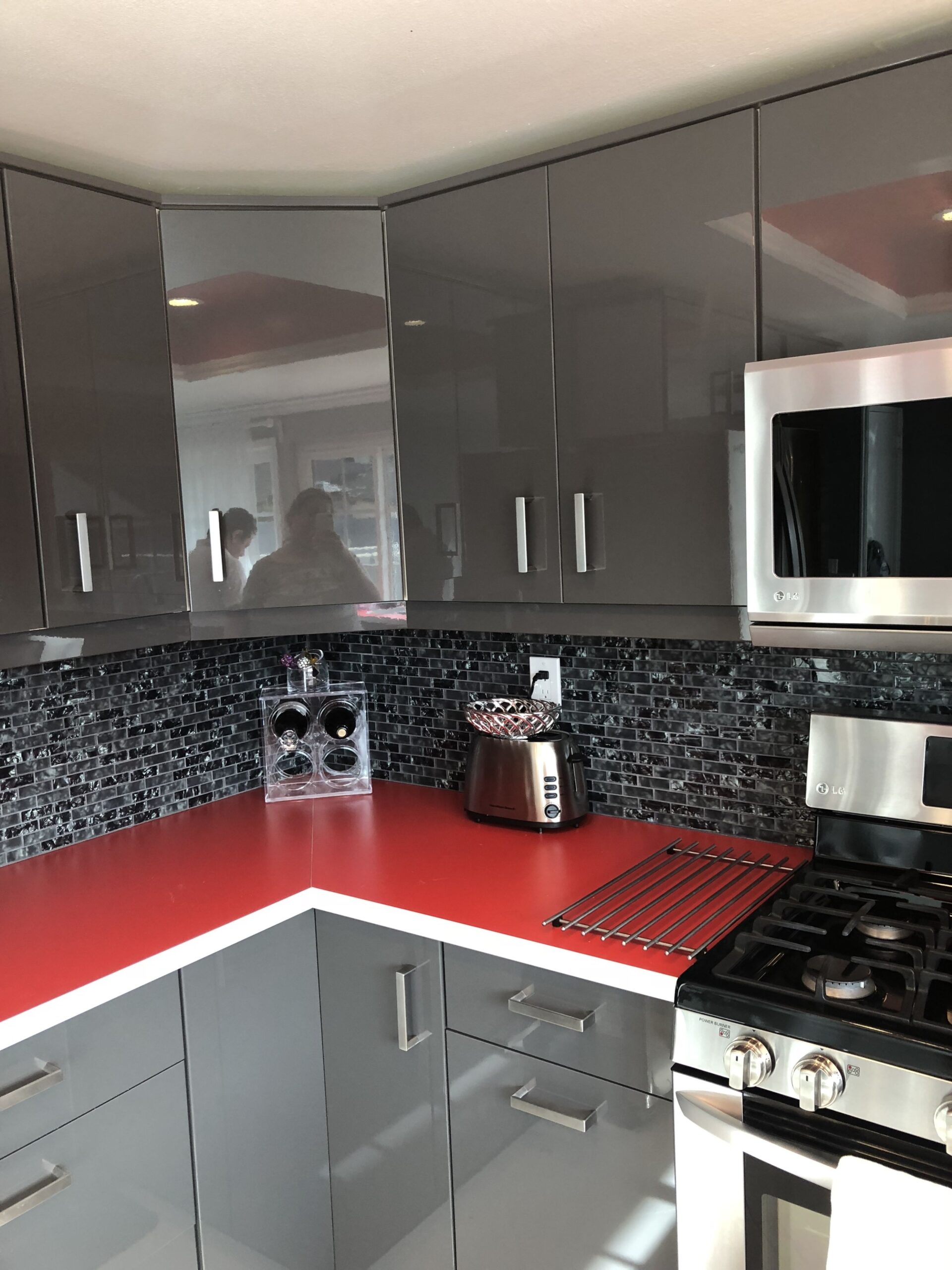Beautiful kitchen with glossy grey cabinets and red counter top